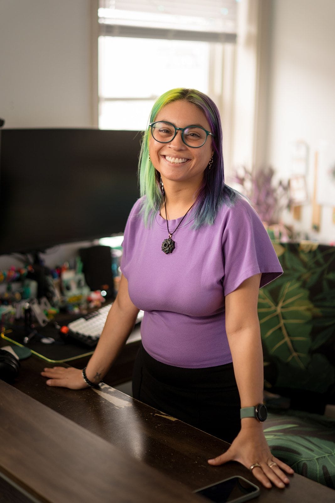 Joa Garcia, owner of Prism Consulting, takes a power stance at her desk