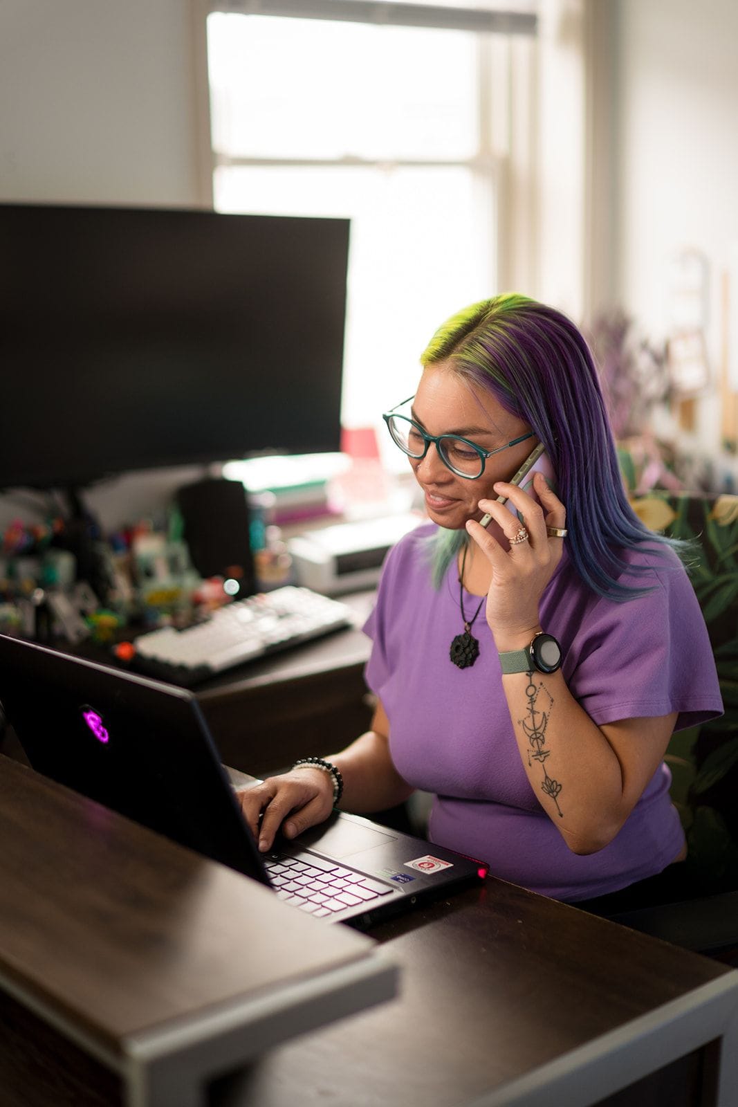 Photo of Joa Garcia, owner of Prism Consulting, answering a phone call in front of her laptop.